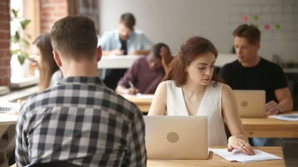 Imprenditrice che lavora su laptop in uno spazio di coworking con imprenditori multietnici — Video Stock