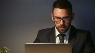 Ev ofis dizüstü kullanarak ciddi başarılı iş adamı geç saate kadar