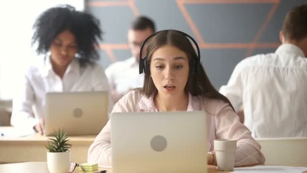 Agente de servicio de atención al cliente sonriente con auriculares mirando a la cámara — Vídeos de Stock