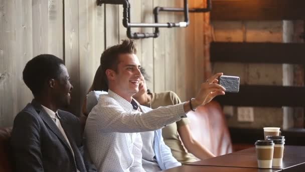Diversos amigos felices haciendo selfie en el teléfono inteligente juntos en el café — Vídeos de Stock