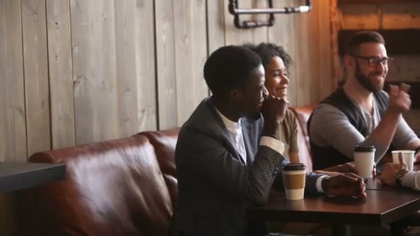 Багатоетнічні молоді друзі демонструють єдність, даючи п'ять на зустрічі в кав'ярні — стокове відео