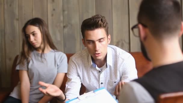 Ontevreden jongeman in gesprek met een psychotherapeut, oplossen van problemen in relaties — Stockvideo