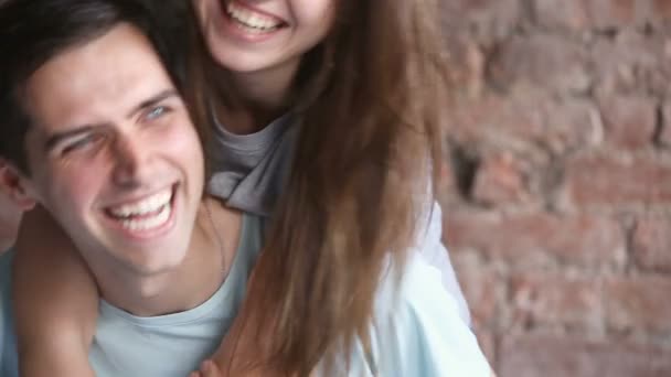 Jovens rindo abraços casal, se divertindo juntos, olhando para a câmera — Vídeo de Stock