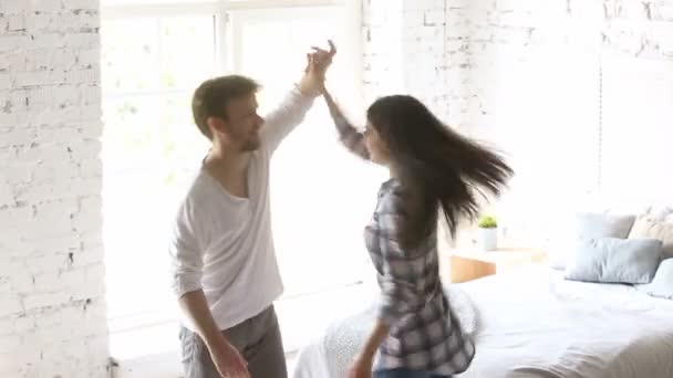 回転を回って女性の寝室で踊る若い幸せなカップル — ストック動画