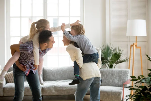 Glückliche junge Eltern huckepack Sohn und Tochter, Familie playin — Stockfoto