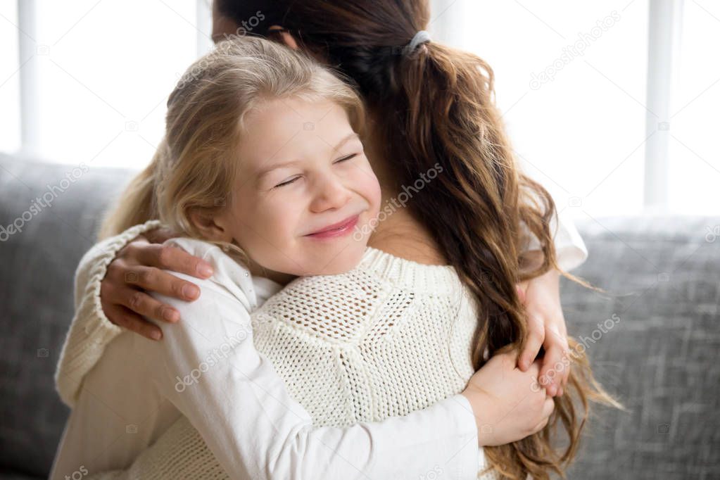 Cute little daughter hugging mother, kids love for mom concept