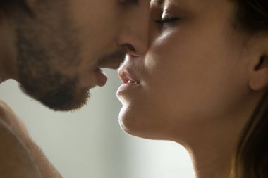 Sensual couple kissing, faces and lips close up side view clipart