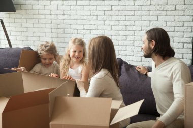 Oturma odasında açma ambalaj oynayan çocuklar ile mutlu anne