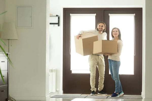 Взволнованная пара, несущая коробки, въезжающие в дом — стоковое фото