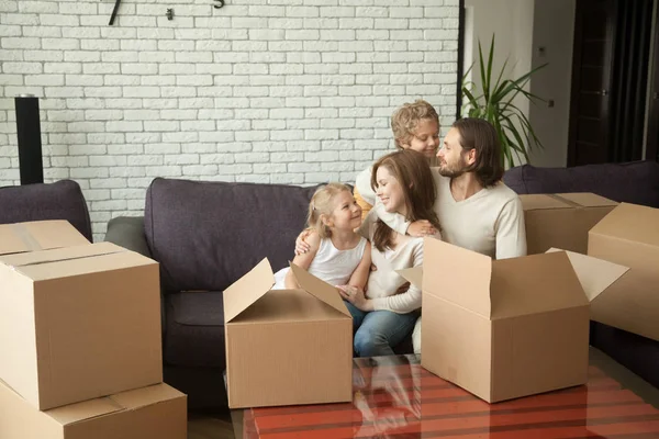 Новые жильцы семьи с детьми и коробки наслаждаясь день переезда — стоковое фото
