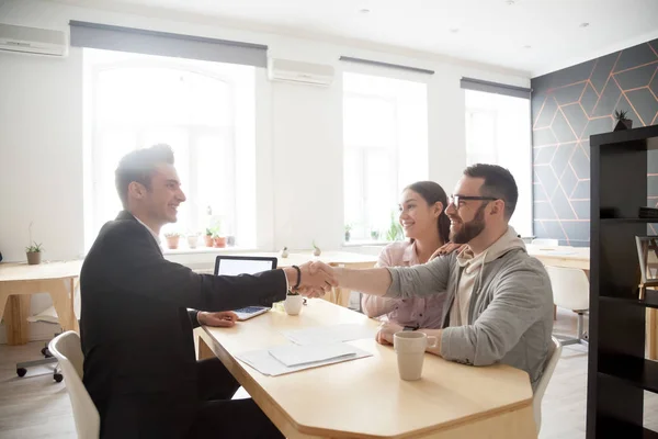 Feliz millennial pareja apretón de manos sonriente asesor financiero, l —  Fotos de Stock