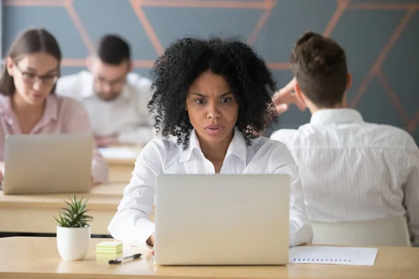 Schockierte afrikanisch-amerikanische Frau schaut gestresst auf Laptop — Stockfoto