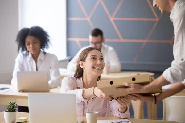 Happy customer ordered pizza in office taking box from courier — Stock Photo, Image