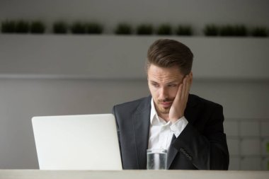 Hayal kırıklığına uğramış işadamı şirket kriz laptop haber okuma