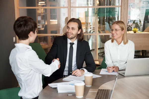 Sonriente hombre de negocios y mujer de negocios estrechando la mano en el grupo mee —  Fotos de Stock