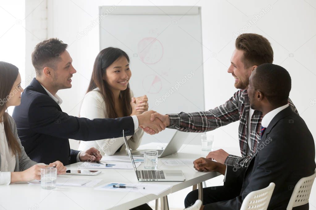 Friendly businessman handshaking client satisfied with successfu