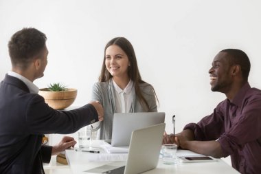 Grup buluşma yerinde erkek partner el sallayarak gülümseyen iş kadını