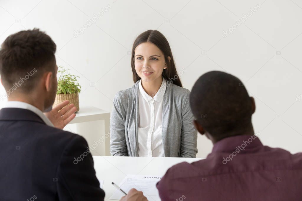 Confident applicant smiling at job interview with diverse hr man