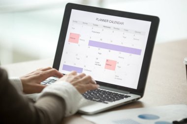 İşkadını planlama gün dizüstü bilgisayar ekranında, özel tertipçi ile planlama, zaman yönetimi kavramı, görünümü kapatın olay yapma çalışan dijital planlayıcısı veya takvim yazılım uygulaması kullanarak