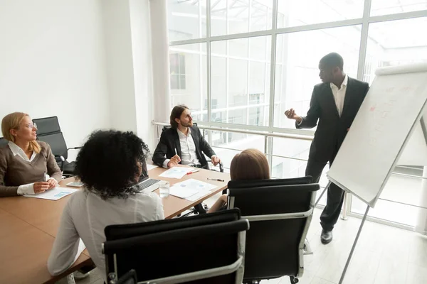 African business coach gives presentation for team at board meet