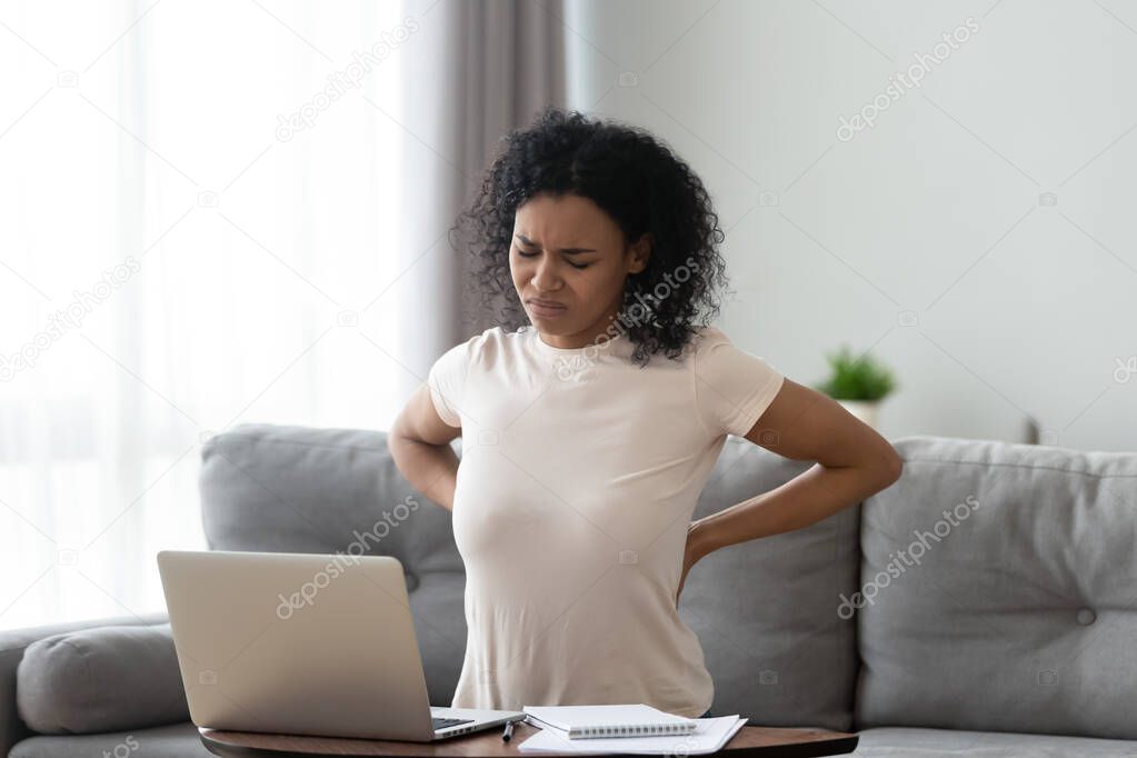 Unhealthy black woman stretching suffering from backache