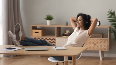 Gülümseyen melez kız evde dinlenip müzik dinliyor.