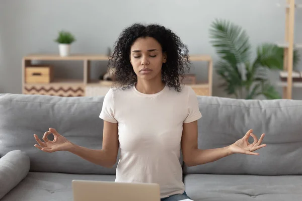 Focused black woman meditating on sofa at home — Stock Photo, Image