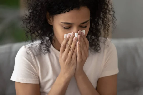 Kranke afrikanisch-amerikanische Frau pustet Nase mit Schnupfen — Stockfoto