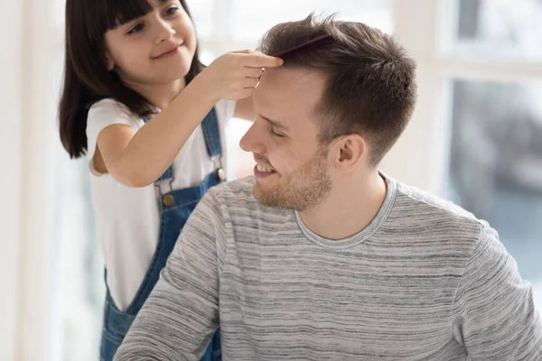 Poco preescolar linda hija peinando padres cabello . — Foto de Stock