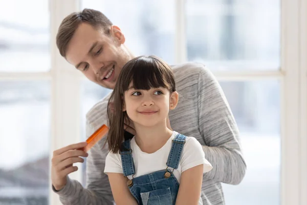 Feliz padre soltero milenario peinando el pelo de la hija . — Foto de Stock