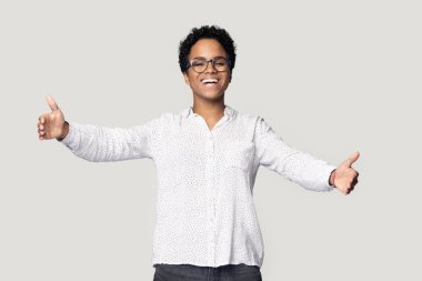 Gözlüklü, gülümseyen Afrikalı Amerikalı kız sarılıyor.