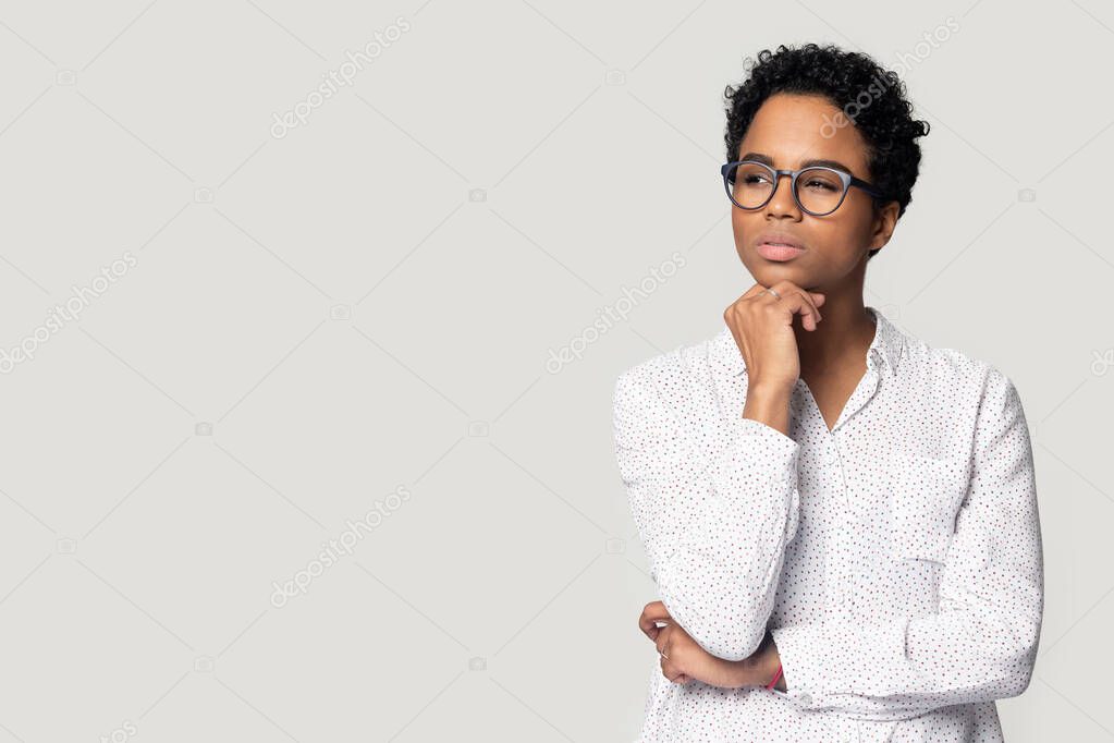 Thoughtful puzzled African American woman looking aside at copy space