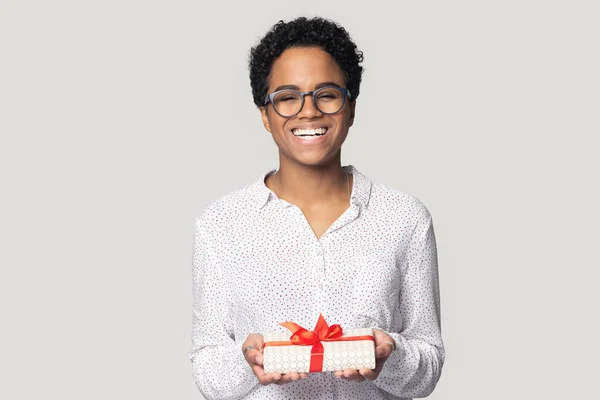 Disparo en la cabeza emocionada joven afroamericana sosteniendo caja de regalo — Foto de Stock
