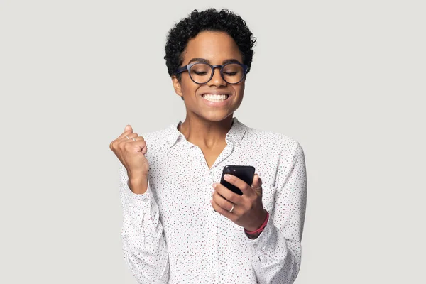 Tiro en la cabeza chica afroamericana feliz usando el teléfono, celebrando el éxito — Foto de Stock