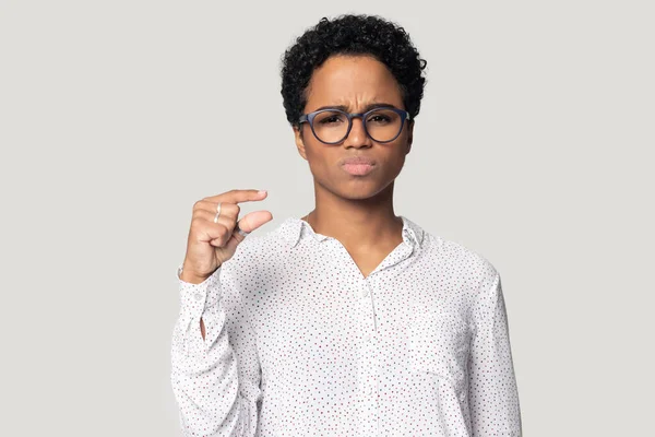 Head shot unhappy African American woman showing little size gesture — Stock Photo, Image