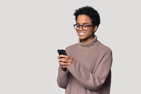 Gözlüklü, gülümseyen Afrikalı Amerikalı kadın telefon kullanıyor, eğleniyor. — Stok fotoğraf