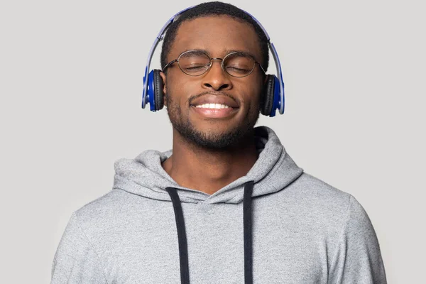 Cabeza disparada sonriendo hombre afroamericano en auriculares disfrutando de la música —  Fotos de Stock