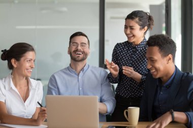 Mutlu çok ırklı işçi takımı iş toplantısında eğleniyor.