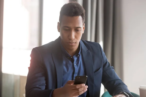 Empresário afro-americano infeliz recebe e-mail no telefone — Fotografia de Stock
