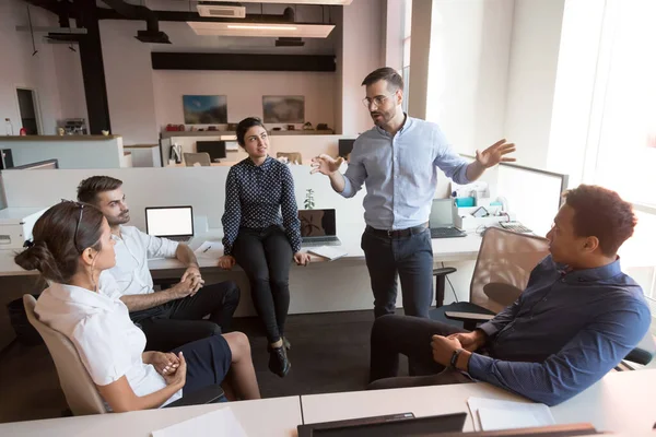 Millennial männliche Führungskraft arbeitet mit vielfältigem Team im Büro. — Stockfoto