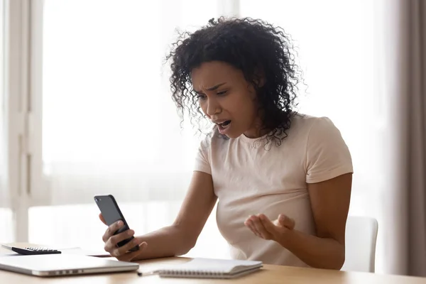 Mulher afro-americana infeliz lendo más notícias, problema com o telefone — Fotografia de Stock