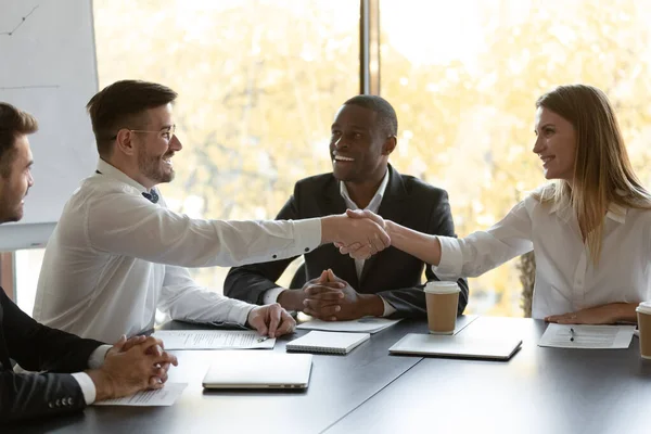 Усміхнені бізнесмени рукостискають, закриваючи успішну угоду на зустрічі — стокове фото