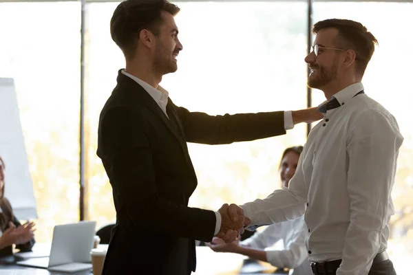 Sonriente apretón de manos del empleador saludo trabajador masculino con éxito —  Fotos de Stock