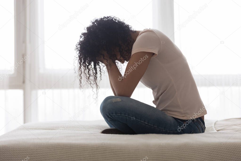 Upset sad African American woman suffering from loneliness side view