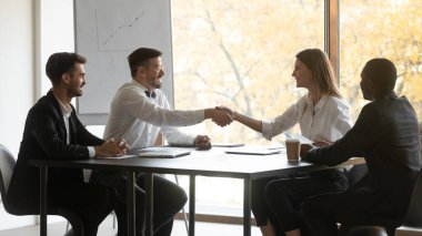 Smiling diverse partners handshake get acquainted at meeting clipart