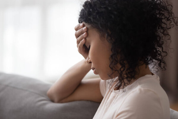 Upset African American woman feeling bad at home close up