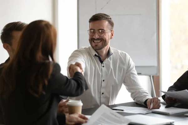 Smiling businessman handshake female colleague at business negotiations — Stock Photo, Image