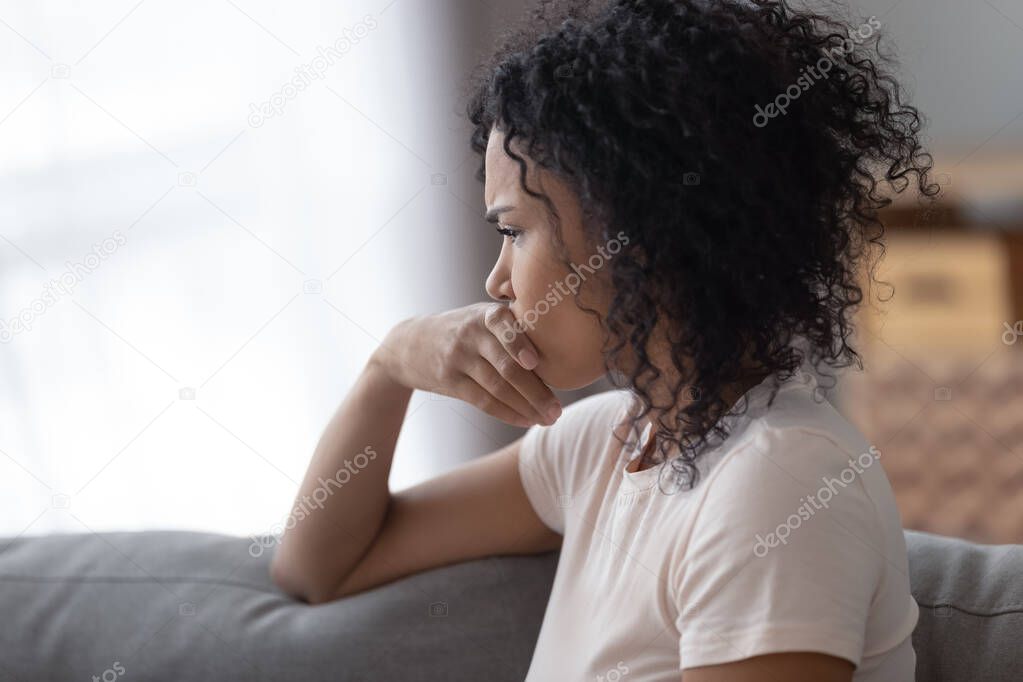Upset African American woman thinking about problems close up