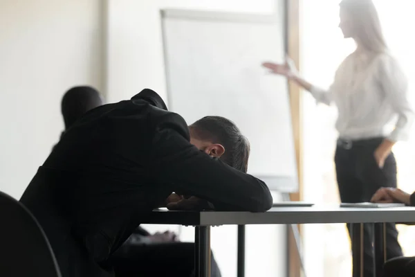 Müder männlicher Mitarbeiter schläft bei Bürobesprechung ein — Stockfoto