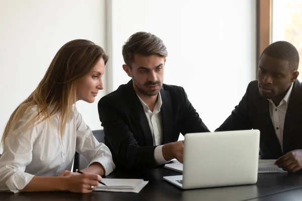 Focused diverse employees cooperating working together at laptop — Stock Photo, Image